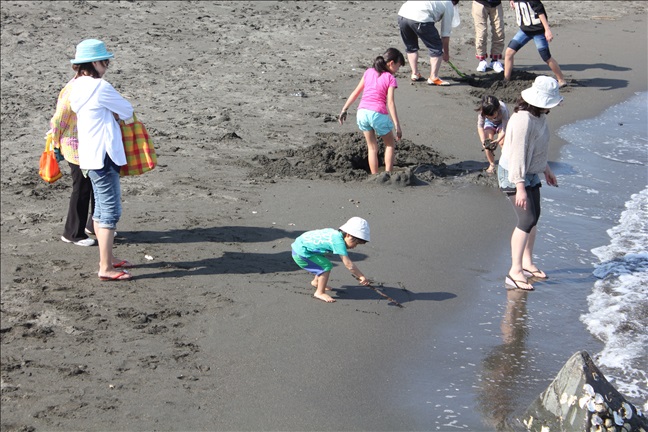 波打ち際で穴掘りを楽しむ子供達